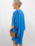 blue v-neck oversized dress on model from side with purse