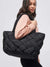 black quilted woven tote on model