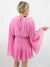 pink pleated bell sleeve romper on model from back