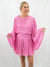 pink pleated bell sleeve romper on model from front
