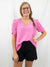 pink top tucked into high waist black shorts on model