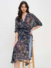 Winter Odyssey Maxi Dress by Meet Me in Santorini in navy floral pattern on model from front sitting on a stool
