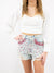 long sleeve white crop top with jeweled shorts on model
