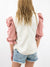 white top with pink puff sleeves on model from back