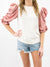 white top with pink puff sleeves on model from front