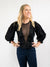 Black blouse with mesh detail and deep v-neckline from front
