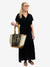 jute tote bag in gold and white metallic cow print paired with black maxi dress