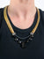 David Aubrey gold and black necklace layered on a black tee