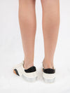 White sneaker wtih black and brown detail from back