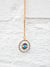 gold chain necklace up close with evil eye pendant