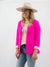 woman in pink blazer styled with graphic tee, denim, and wide-brim hat