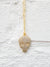 close up of gold necklace with pave skull