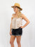 smock top in tan and white pattern paired with denim shorts and straw sun hat