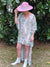 model in high low snake print dress with pink wide brim hat and short white booties