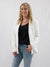 woman with white blazer, classic black tee, and denim jeans
