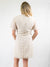 wrap dress in white with pompom detailing view from back